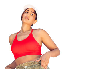 Young woman wearing a red crop top and baseball cap, posing with confident attitude