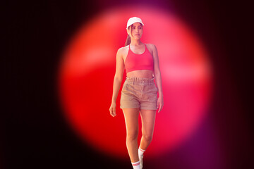 Confident young woman walking with style against a vibrant red spotlight background