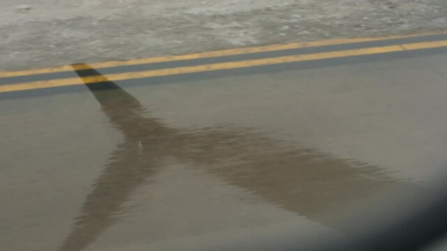 Reflection of an airplane winglet wile taxiing on the tarmac heading to the gate 