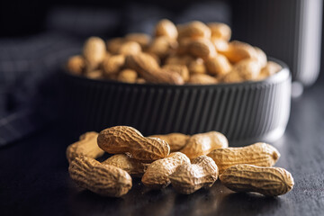 Peanuts in shell. Groundnuts on black table.