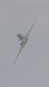 Large white private business Jet during flight under blue sky with clouds