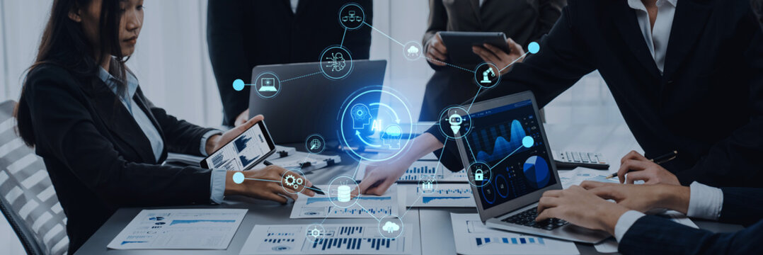 A team of professionals engages in a collaborative meeting in a modern office, analyzing data and sharing insights using various digital devices for effective decision-making. Trope - Powered by Adobe