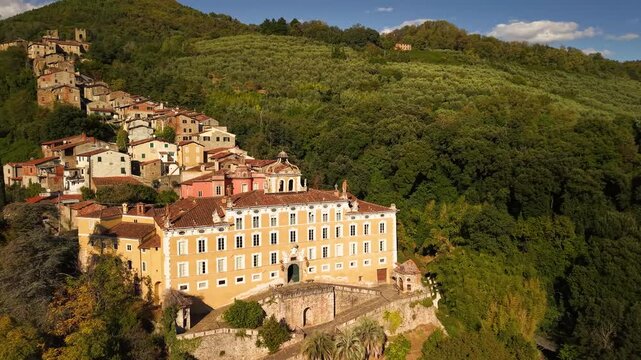 Aerial 4K of Collodi, the vertical medieval village. Cinematic drone flight over the historic stone houses cascading down the hill, Tuscany, Italy.