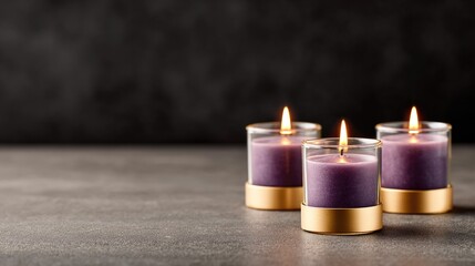 Three purple candles burning in elegant golden holders