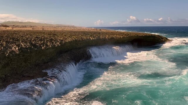 Shete Boka National Park in Curacao. Waves pound against coral rock formations and saltwater splashes high into the air. Cliff-like sea coves.