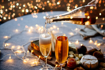 Pouring sparkling wine or champagne served for Christmas or New Year eve celebration.