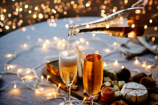 Pouring sparkling wine or champagne served for Christmas or New Year eve celebration. - Powered by Adobe