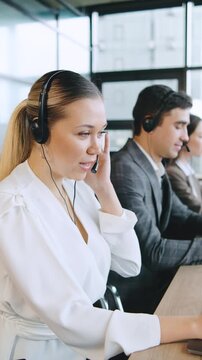 Busy call center team assisting clients with technical support and financial inquiries during work hours in a modern office environment,vertical video