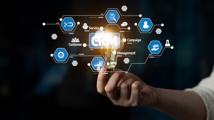 A conceptual image illustrating customer relationship management through a hand holding a lightbulb with digital icons. Represents innovation and strategic marketing solutions. Tessel