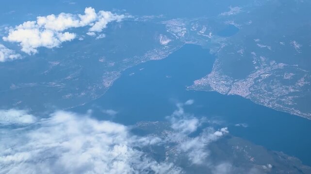 plane flies calm blue lake under cloudy sky natural air travel rome to easyjet beauty scenic flight aircraft window seat clouds transportation aviation water body journey 