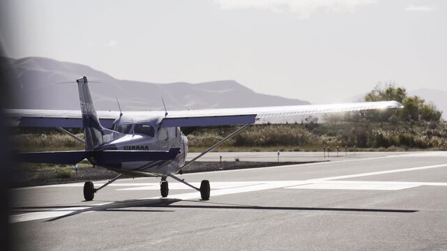 Sunlight bouncing off small cessna airplane preparing to take off on runway