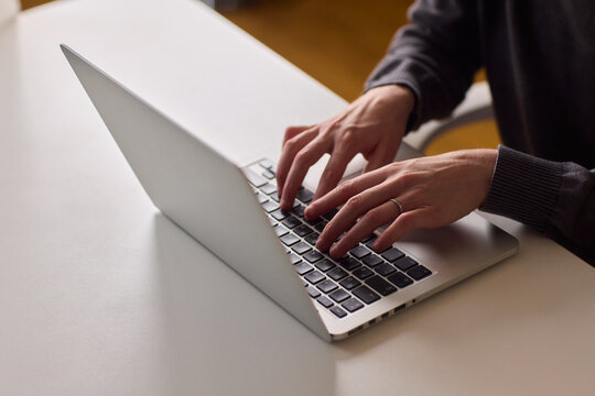 Woman learning in comfortable home setting, Female student engaged with her laptop at home, Young woman in wheelchair actively studying with assistive tools at her desk