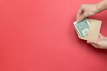 hand placing dollar into red envelope on vibrant red background, closeup of giving gesture for donation or fundraiser, warm atmosphere emphasizing support, generosity, and community impact