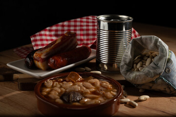 Preparing spanish bean stew with ingredients and preserves