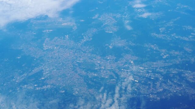 towns lakes valleys below airplane settlement patterns water bodies beneath clouds floating blue landscape from aerial view civilization structure perspective 