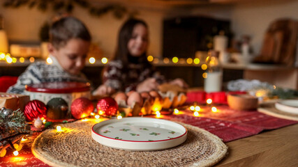 Christmas table setting with children, decorations, and festive food