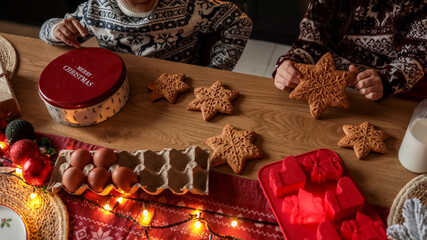Children baking and decorating Christmas star-shaped gingerbread cookies