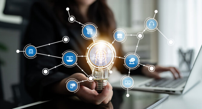 Capture the essence of business innovation with a light bulb and technology icons. This image showcases the power of creative ideas and digital connections in a modern office. Crux - Powered by Adobe