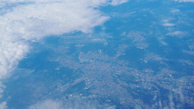 motion displays towns lakes valleys below airplane clouds floating across blue landscape sequential framing progression to from left right aerial civilization 