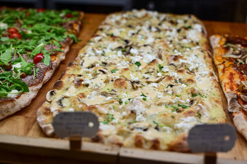 Authentic Italian pizza in a restaurant display window in Rome, Italy.  Different type of traditional Roman styple pizza . 