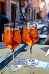 Two glasses of Aperol spritz cocktail  againts little square  in  Rome , Italy.  Concept of Italian gastronomy and travel. 