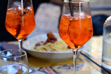 Fresh pasta    tonnarelli alla carbonara and Aperol Spritz  at  typical italian resaturant at Trastevere   neighbourhood at Rome 