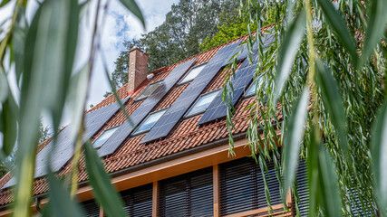 Terracotta roof with solar panels harnessing sunlight for electricity, surrounded by greenery, showcasing sustainable technology and ecological innovation in residential energy solutions