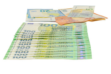 Multiple one hundred euro banknotes arranged in a neat stack with additional fifty, twenty, ten, and five euro notes placed above, isolated on a plain white background, tilted view studio shot.