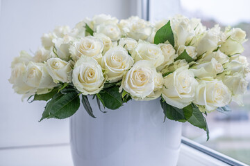 White roses arranged beautifully in a modern vase, creating an elegant floral decoration for celebrations, anniversaries, and special occasions with a soft background ambiance