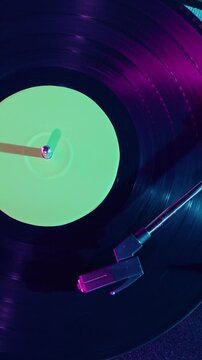 Retro Vinyl record player playing music, close-up macro shot of vintage LP disc old phonograph spinning. Retro music player at home.