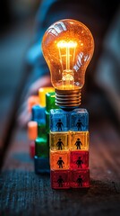 Teamwork and strategy concept   red illuminated lightbulb placed next to colorful stacked blocks with black person symbols on dark wooden surface