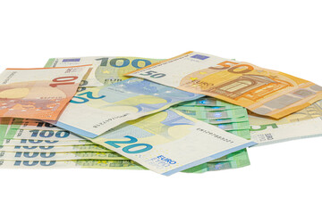 Pile of assorted euro banknotes including one hundred, fifty, twenty, ten and five euro notes scattered on a plain white background, studio shot in tilted view, close-up macrophotography.