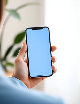 Hand holding modern smartphone with empty screen. Mobile phone mockup for app developers and designers. Ideal for showcasing digital products and mobile applications.
