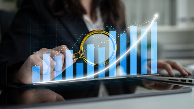 A professional analyzing financial data using a magnifying glass over bar graphs and line charts. The image captures the essence of data-driven decision-making in business. Impute