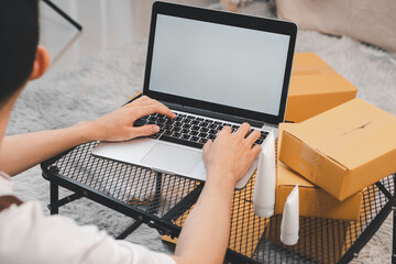 Startup small business owner packing boxes for online customer delivery. Entrepreneur managing e-commerce orders, shipping parcels, and running home-based business operations from home office.