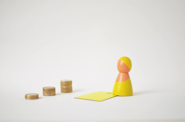 Wooden pawn and credit card symbolizing financial progress with growing coin stacks
