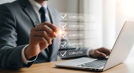 Businessman using pen pointing at digital interface showing check mark boxes with completed tasks on laptop.