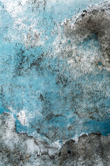 Turquoise glacial ice forming intricate abstract shapes revealing layered blue and white textures within frozen winter wilderness landscape