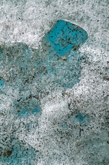 Turquoise glacial ice forming intricate abstract shapes revealing layered blue and white textures within frozen winter wilderness landscape