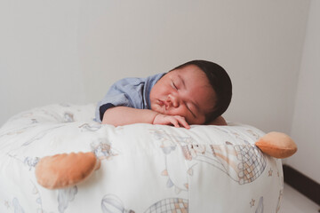 Cute newborn baby boy sleeping peacefully in white crib and soft nest. Close-up of infant resting on bed, symbolizing childhood innocence, comfort, and family love. Perfect for baby care themes.