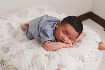 Cute newborn baby boy sleeping peacefully in white crib and soft nest. Close-up of infant resting on bed, symbolizing childhood innocence, comfort, and family love. Perfect for baby care themes.