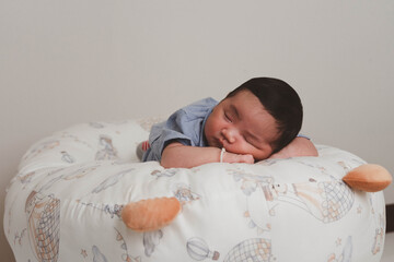 Cute newborn baby boy sleeping peacefully in white crib and soft nest. Close-up of infant resting on bed, symbolizing childhood innocence, comfort, and family love. Perfect for baby care themes.