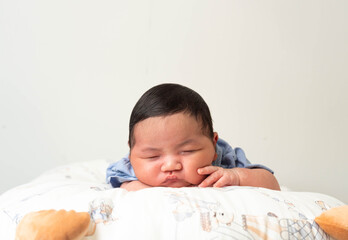 Cute newborn baby boy sleeping peacefully in white crib and soft nest. Close-up of infant resting on bed, symbolizing childhood innocence, comfort, and family love. Perfect for baby care themes.