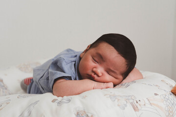 Cute newborn baby boy sleeping peacefully in white crib and soft nest. Close-up of infant resting on bed, symbolizing childhood innocence, comfort, and family love. Perfect for baby care themes.