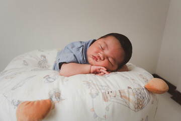 Cute newborn baby boy sleeping peacefully in white crib and soft nest. Close-up of infant resting on bed, symbolizing childhood innocence, comfort, and family love. Perfect for baby care themes.