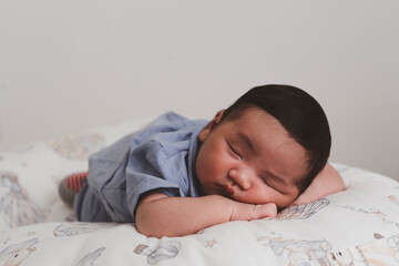 Cute newborn baby boy sleeping peacefully in white crib and soft nest. Close-up of infant resting on bed, symbolizing childhood innocence, comfort, and family love. Perfect for baby care themes.