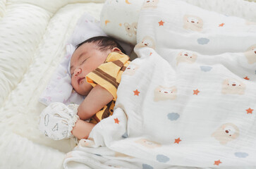 Cute newborn baby boy sleeping peacefully in white crib and soft nest. Close-up of infant resting on bed, symbolizing childhood innocence, comfort, and family love. Perfect for baby care themes.