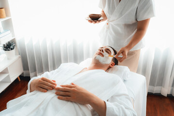 Serene ambiance of spa salon, man customer indulges in rejuvenating with luxurious face cream...