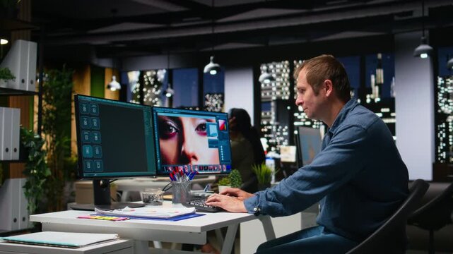 Graphic developer working with photo editing software at the office, digital media production with professional tools. Dual monitors for productivity in the graphic design industry. Camera A.