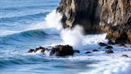 Waves crashing against rocky coastline with splashing water and rugged cliffs